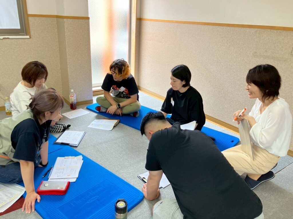 児童発達支援・放課後等デイサービス職員研修で「肯定的な注目」をテーマに、ペアレントトレーニングのグループワークを行う職員の様子